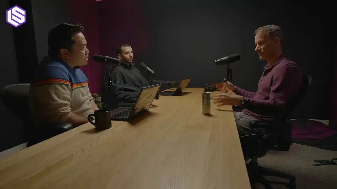 Jeff Dean über Google's Ranking Prozess 6 Weite Studioaufnahme: drei Personen an einem Holztisch, der Gast gestikuliert; Mikrofone und Laptops sind deutlich sichtbar.