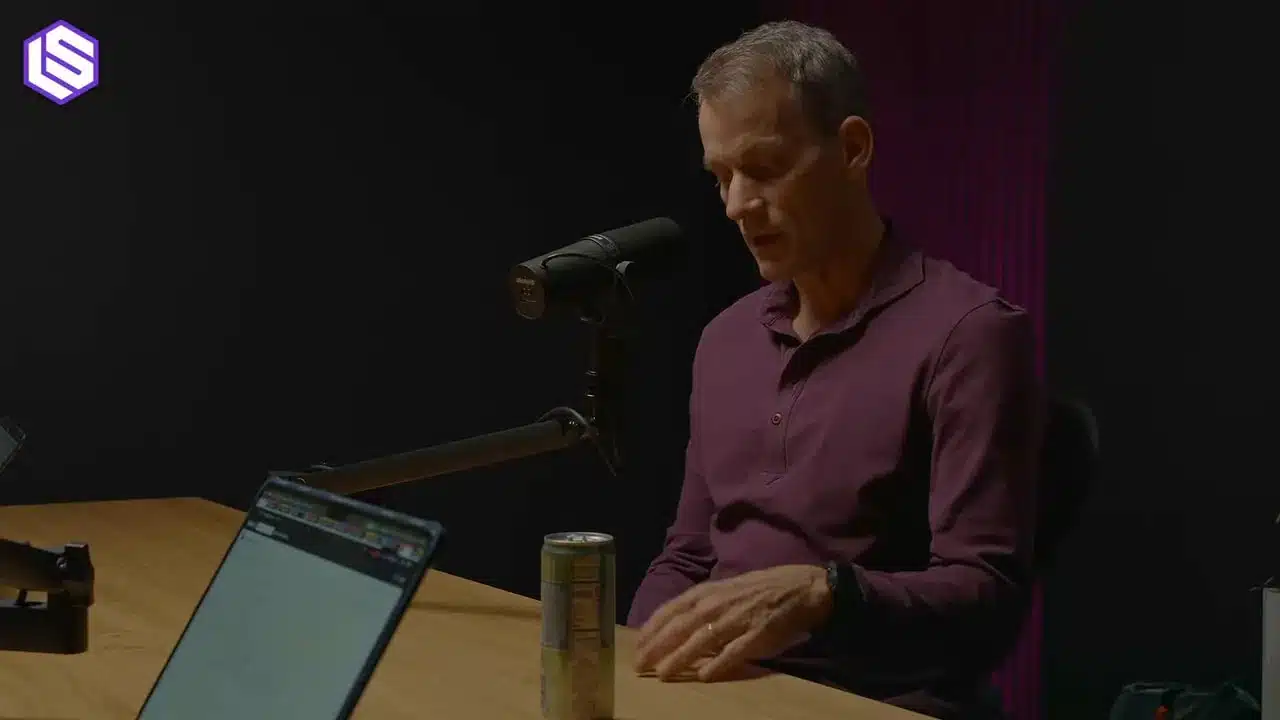 Jeff Dean über Google's Ranking Prozess 5 Interview‑Gast blickt auf den Tisch; deutliches Mikrofon, Laptop und Getränkedose im Vordergrund.